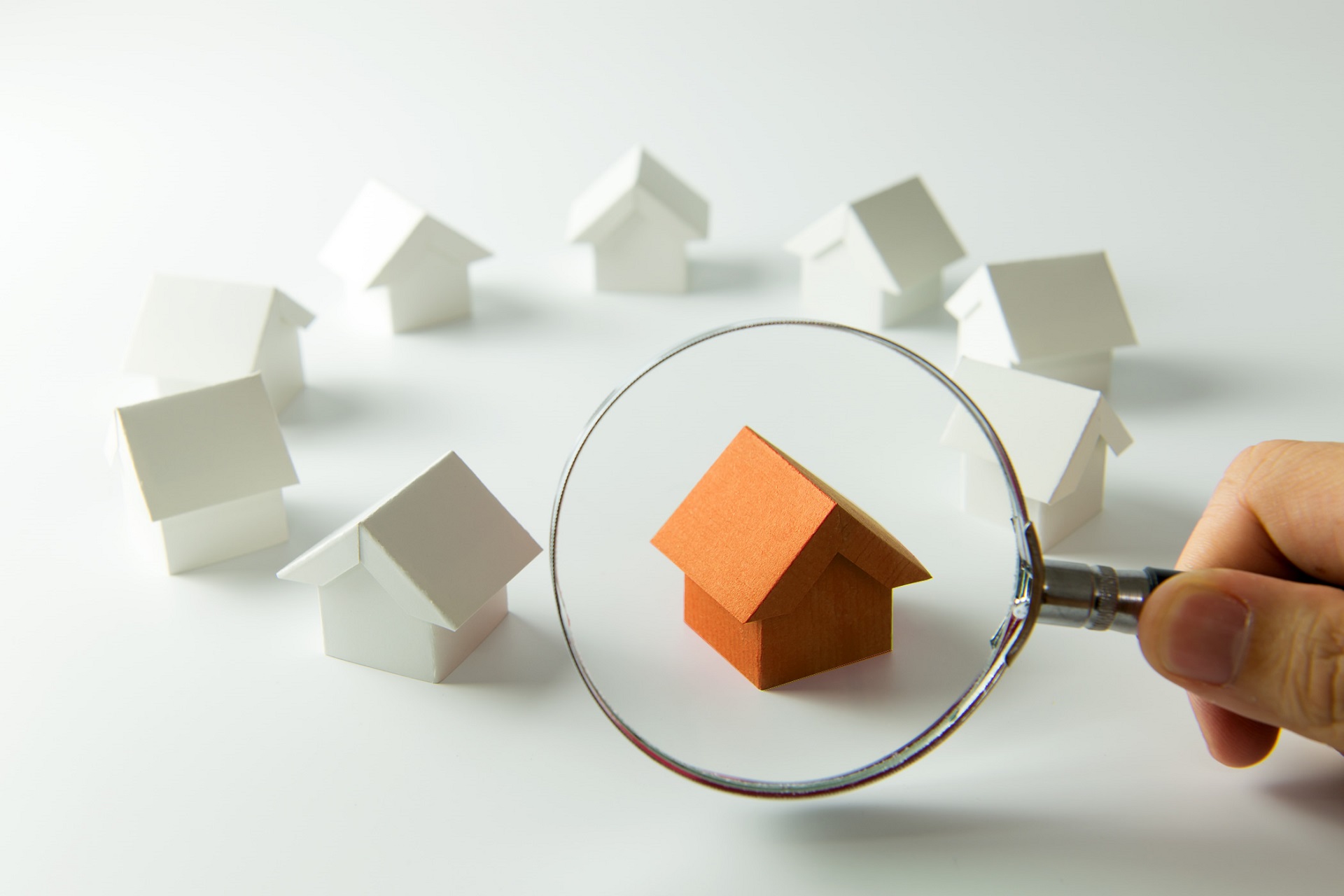 Lupe mit Häusern als Sinnbild für bessere SEO für Immobilienmakler
